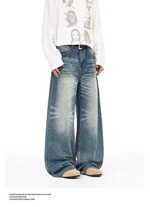 Detail of vintage washed wide-leg jeans featuring cat-whisker patterns and drape effect