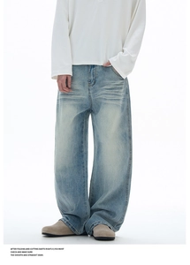 Vue détaillée du jean baggy bleu clair avec délavage vintage et effet moustaches