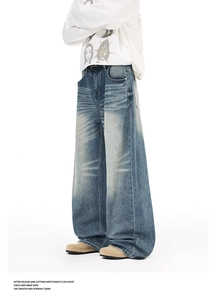 Macro detail of high-waist wide-leg jeans with vintage washed whiskers and loose fit drape