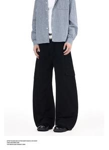 Detail of loose-fit black cargo pants with multiple pockets and oversized silhouette