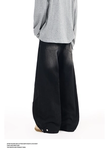 Detail view of washed black wide-leg denim pants showing button hem and baggy back pockets