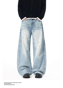 Detail view of light blue distressed wide-leg jeans with 3D stitching and knee rips