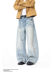 Detail view of structured curved seams and loose baggy fit on light blue washed jeans