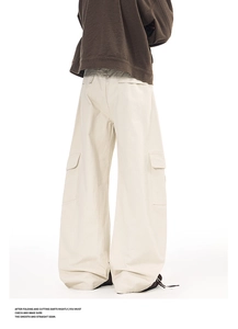 Detail view of cargo pockets and back stitching on loose-fit cream white utility trousers
