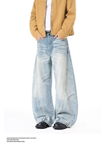 Detail of light blue baggy jeans with vintage wash effects and button hem design