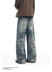 Detail of vintage blue straight-leg jeans featuring whiskers and washed distressing