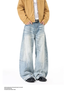 Detail of light blue wide leg jeans featuring vintage wash and unique curved stitching