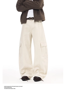 Close-up of cream cargo pants featuring utility pockets and durable knee stitching