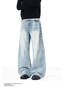 Detailed view of light blue wide-leg jeans with pleated knees and distressed wash