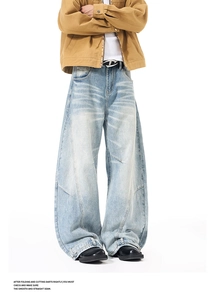 Detail shot of vintage wash blue jeans with cat-whisker texture and curved seam stitching