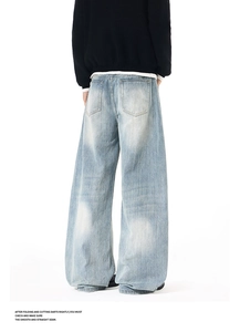 Macro detail of high-quality light blue washed denim fabric with distressed white fade textures