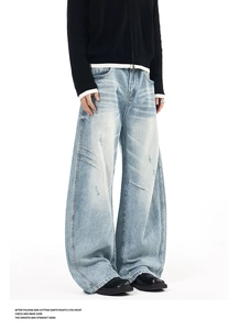 Detail of light blue wide-leg jeans with darted seams and distressed finish