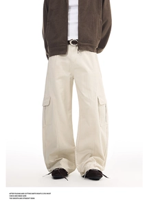 Detail of cream cargo pants featuring large side flap pockets and premium cotton twill
