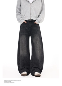 Macro shot of curved side seams on premium washed black wide-leg slouchy denim jeans