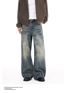 Close-up of vintage wash details and distressed whiskering on blue straight-leg denim jeans