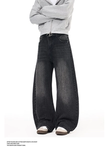 Close-up of washed gray wide-leg jeans with vintage texture and black leather belt