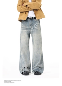 Detail of vintage washed light blue wide-leg jeans with retro whiskers and faded texture