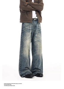 Detail of vintage washed wide-leg jeans featuring heavy denim texture and stacked hems
