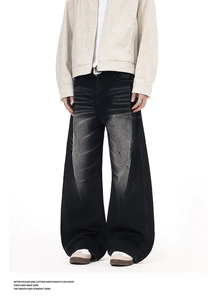 Detail of washed grey wide-leg denim jeans with distressed cat-whisker effect