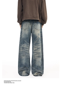 Detail view of vintage washed denim jeans featuring whiskering texture and back pockets