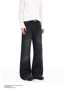 Detailed close-up of retro washed denim jeans with vintage whiskers and a metal buckle belt
