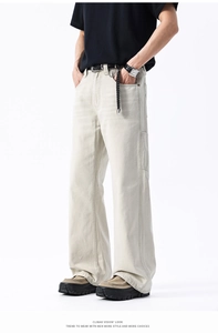 Dettaglio dei pantaloni cargo beige larghi che mostra il tessuto di tela e le cuciture