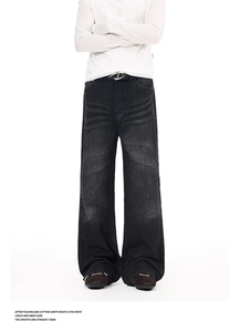 Detailed view of washed vintage denim texture and cat whiskers pattern on flare jeans