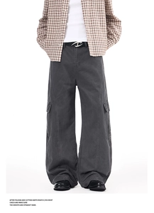 Detailed view of dark grey wide-leg cargo pants with flap pockets and textured fabric