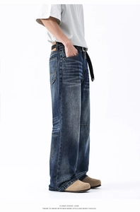Dettaglio dei jeans vintage blu scuro a gamba larga con effetto baffi lavati
