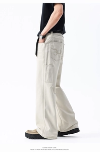 Vista laterale dettagliata dei pantaloni cargo beige da uomo con cintura nera e ricami