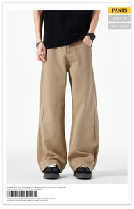 Dettaglio dei pantaloni kaki a gamba larga in cotone twill con cuciture laterali decorative