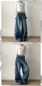 Gros plan sur un jean bleu délavé vintage avec broderies étoiles sur les coutures latérales