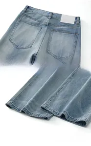 Détail du jean bleu clair montrant les poches arrière et les finitions de l'ourlet