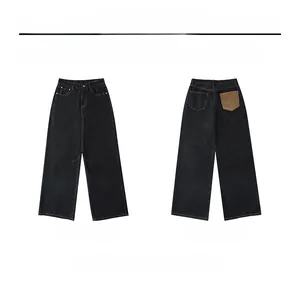 Front and back view of baggy black raw denim jeans featuring a distinct brown M pocket detail