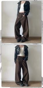 Detail shot of brown wide-leg pants with metal rivets paired with black leather jacket