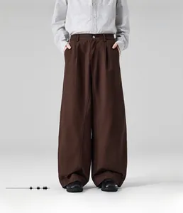 Detail view of men's loose straight-fit dark brown casual trousers with visible stitching