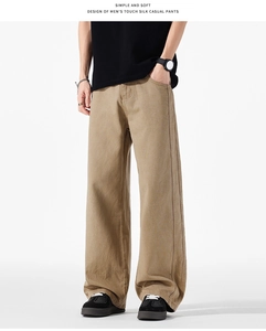 Dettaglio dei pantaloni kaki a gamba larga che mostrano il morbido tessuto in twill