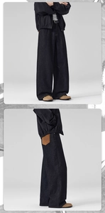 Close-up of baggy straight-leg raw denim jeans with contrast brown leather pocket detail