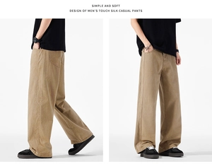 Dettaglio dei pantaloni ampi kaki dal tocco setoso con cuciture a vista e tasche