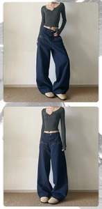 Detail of dark blue oversized cargo pants featuring silver star-shaped metal rivet studs