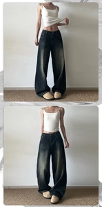 Détail d'un jean vintage à taille haute et jambe large en denim gris foncé délavé
