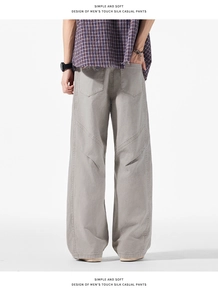 Détail du pantalon cargo large avec tissu effet soie et poches arrière en forme de bouclier