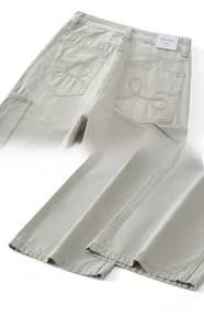 Dettaglio dei pantaloni cargo con ricamo sulla tasca posteriore e orlo a doppia cucitura