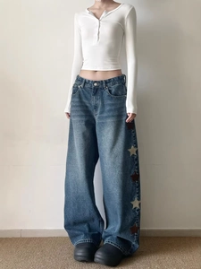 Tenue streetwear pour femme avec jean large brodé d'étoiles et haut blanc à manches longues