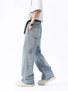 Jean homme bleu clair à coupe droite large, délavage vintage et ceinture en studio