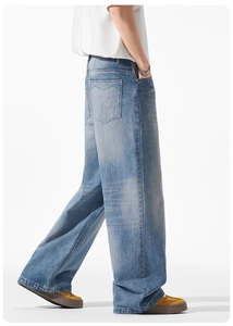 Detail der grünen Wellenstickerei auf der Gesäßtasche der hellblauen Wide Leg Jeans