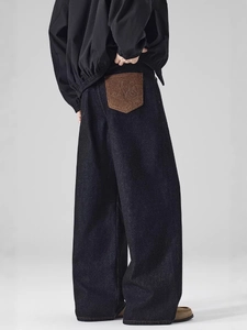 Dark blue loose straight-leg jeans with a premium brown embossed leather back pocket