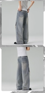 Detailed view of rear pockets and distressed light blue wash on wide-leg denim pants