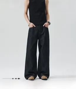 Detail of baggy loose straight leg jeans showing washed texture and heavy fabric draping