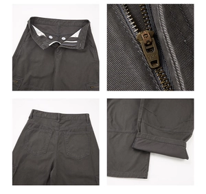 Detail view of dark grey cargo pants showing YKK zipper and twill fabric texture